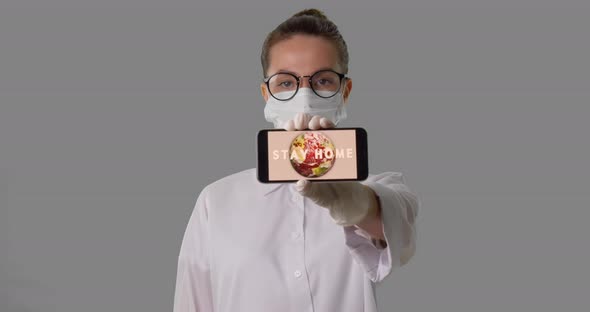 Medical Worker Shows the Phone with a Sign Announcing To Stay Home