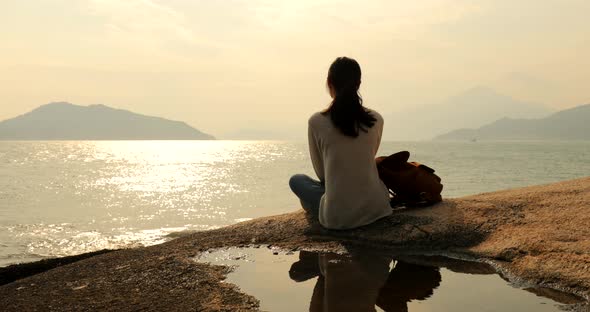 Woman traveler enjoy the view of the sea during sunset