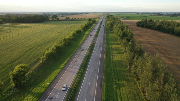 Top View of the Road with Cars and Fields Around the road.Fields and Trees Near the Highway with