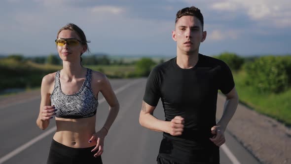 Sporty Couple Running on Road