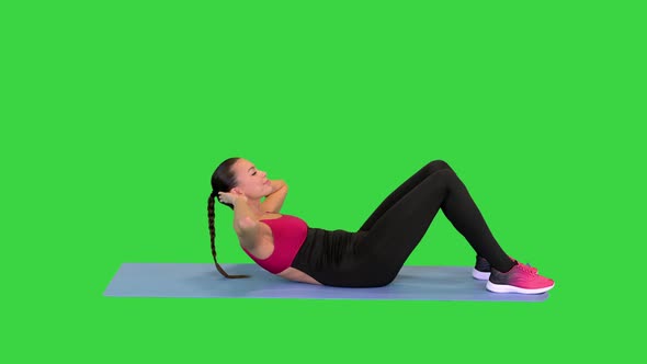 Beautiful Sporty Woman Doing Exercise for Abs on the Floor on a Green Screen Chroma Key