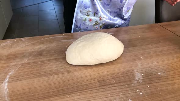 The woman kneads the dough