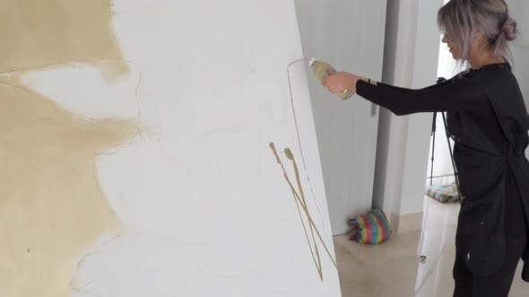 Talented Female Artist Applying Paint And Spreading With Paintbrush On A Large Canvas Inside Her Art