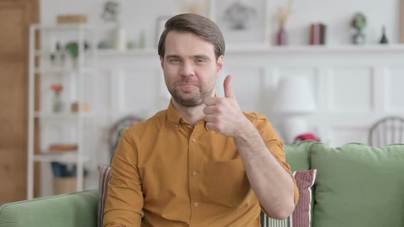 Portrait of Young Man Showing Thumbs Up at Home