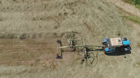 Tractor with Rake Tedders on the Farm Field