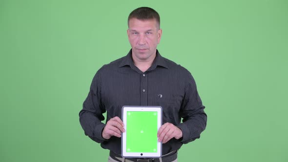 Macho Mature Businessman Showing Digital Tablet