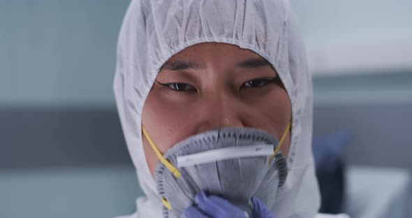 Asian Doctor Taking Off Mask and Face Shield