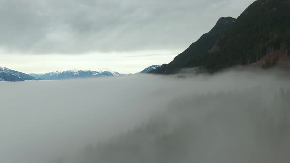 Aerial View of Canadian Mountain Landscape Covered in Fog Over Harrison Lake