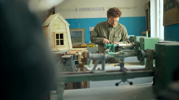 Carpenter Working with Machine in Workshop