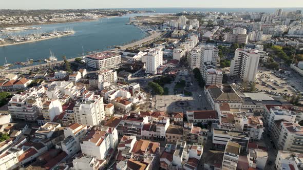 Aerial wide over urban cityscape, Portimao downtown Buildings by the Arade river, Portugal