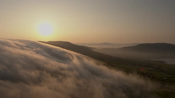 Early morning clouds drift over the mountains in Co Kerry Ireland as the sun shines during the summe