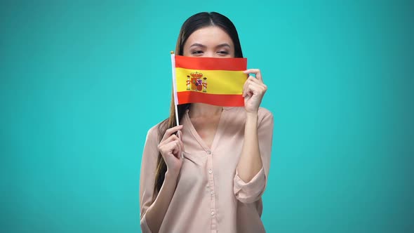 Girl Covering Face With Spanish Flag, Learning Language, Education and Travel