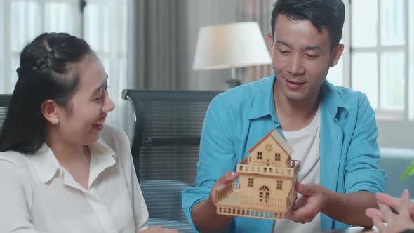 Close Up Of Asian Couple Receives The House Model From A Real Estate Agent