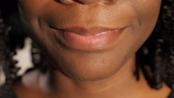 Pretty Young Woman with Black Curly Hair Smiles Cheerfully