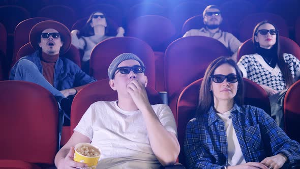 A Man Sneezes at the Cinema with Other People Around