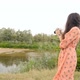 A Brunette Girl with Long Hair Photographs the River - VideoHive Item for Sale