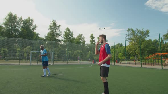 Soccer Referee Giving Final Whistle Notifying End of Game Match