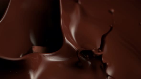 Super Slow Motion Shot of Raw Chocolate Chunks Falling Into Melted Chocolate at 1000Fps.