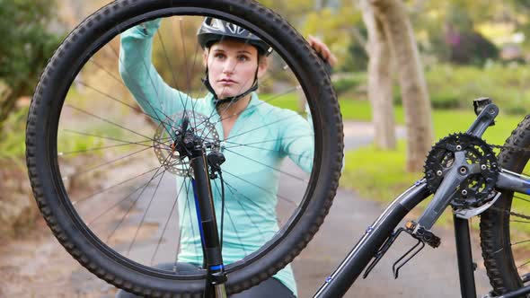 Female cyclist repairing bicycle tyre