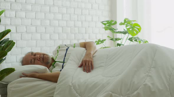 Elderly man close eyes smile sleep and sweet dream on bed in bedroom