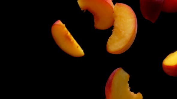 Closeup of Juicy Halves of Ripe Apricots Flying on a Black Background