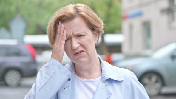 Old Woman with Headache Standing Outdoor