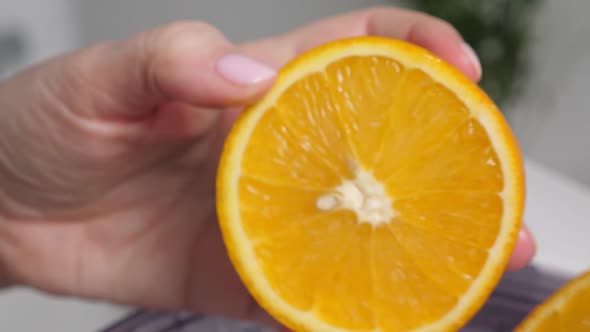 Woman Cutting Orange Fruit with Knife