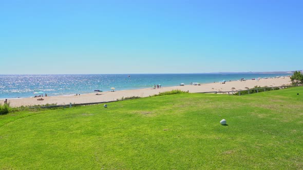 Grassy Field Near a Pleasant Looking Beach and Glistering Ocean Water in Vale Do Lobo Portugal