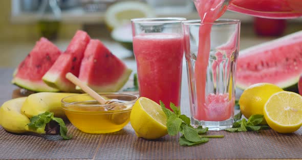 Watermelon Banana Orange Smoothie is Poured Into a Glass on the Background of Fresh Fruits