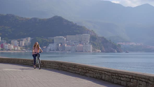A Young Woman Rides a Bicycle in the City of Budva a Famous Tourist Place in Montenegro