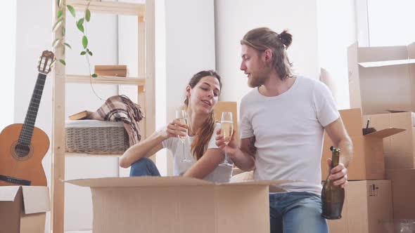 Successful Caucasian Pair Celebrating Move to Their New Flat Drinking Champagne in Slowmotion