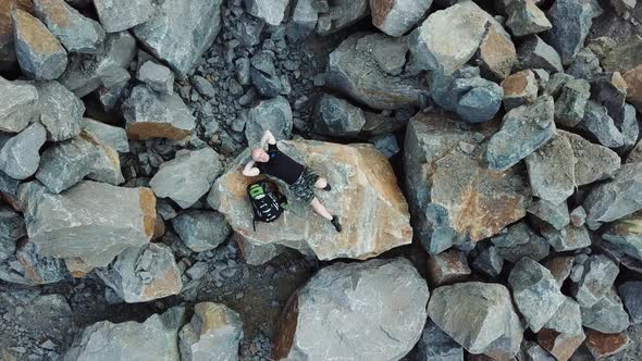 Bald Man Lays on a Large Stone