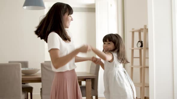 Cheerful Mom and Daughter Playing Active Games at Home