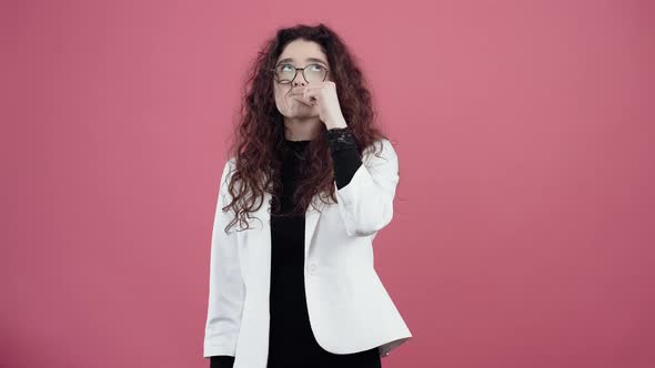 Serious Young Woman with Curly Hair Looks Like a Basket with Thousands in Her Mouth That She Will