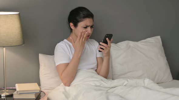 Failure Indian Woman Reacting to Loss on Smartphone in Bed