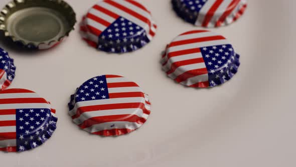 Rotating shot of bottle caps with the American flag printed on them 