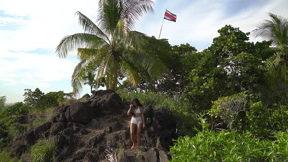 Sexy woman hiking and trekking over rocks on Costa Rica mountain ridge