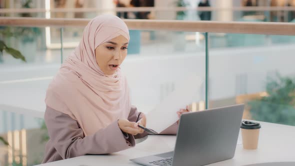 Young Islamic Woman Sitting in Cafe Conducting Online Lesson Talking on Video Conference Using