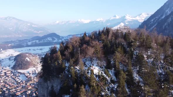 Drone circle around a small, steep mountain with lots of fir trees called "burgfluh" near "Wimmis" i
