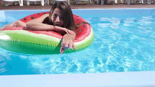 Gorgeous Young Woman in Swimming Ring in a Pool