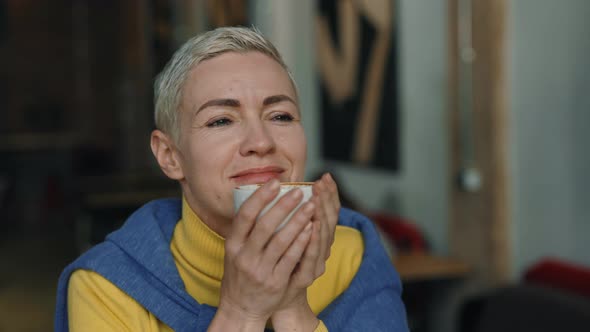 Middle Aged Woman Enjoying Coffee While Resting at Cafe