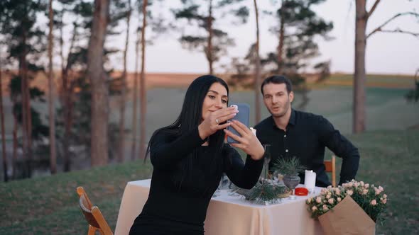 The Woman in Love Takes a Selfie with the Man She Loves During the Romantic Nature Dinner in Which