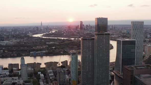 Forwards Fly Above Isle of Dogs with Panoramic View of Romantic Sunset Above Thames River Flowing