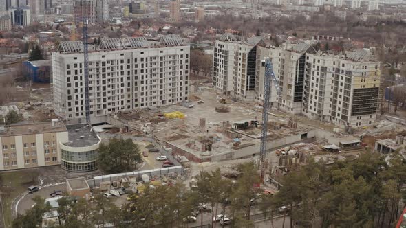 Top View of Construction Site, Hoisting Construction Cranes and the Construction of New High Office