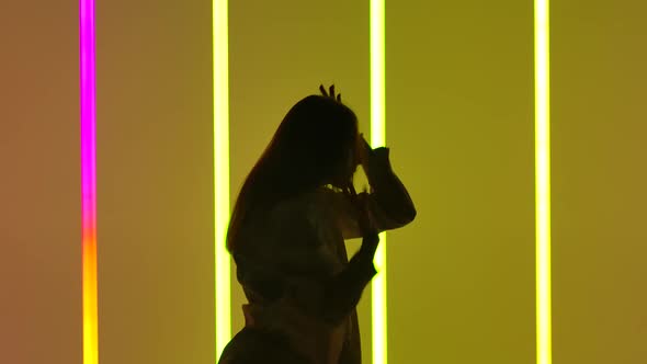 Woman Dancing Contemporary in the Studio Against the Background of Multicolored Neon Tubes