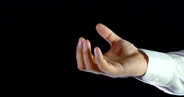 Close-up of Male Hand in White Shirt Unclenches Fist and Spread Fingers on Black Isolated Background