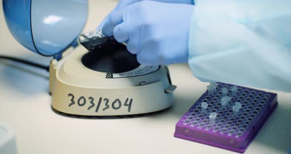Scientist Puts Virus Samples Into Machine at Biotechnology Molecular Laboratory. alt