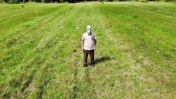 Man in Gas Mask Outdoors Not Able To Breath, Out of Oxygen, in Green Meadow, Surreal, Disaster