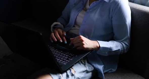 Woman Using Search a Laptop on a Sofa at Home Checking Social Media