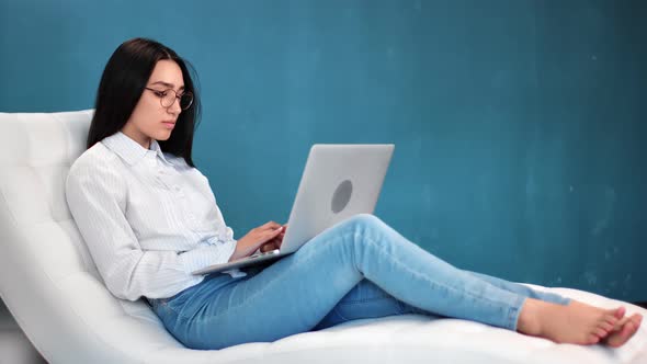 Freelancer Woman Sitting on Comfy White Armchair Use Laptop